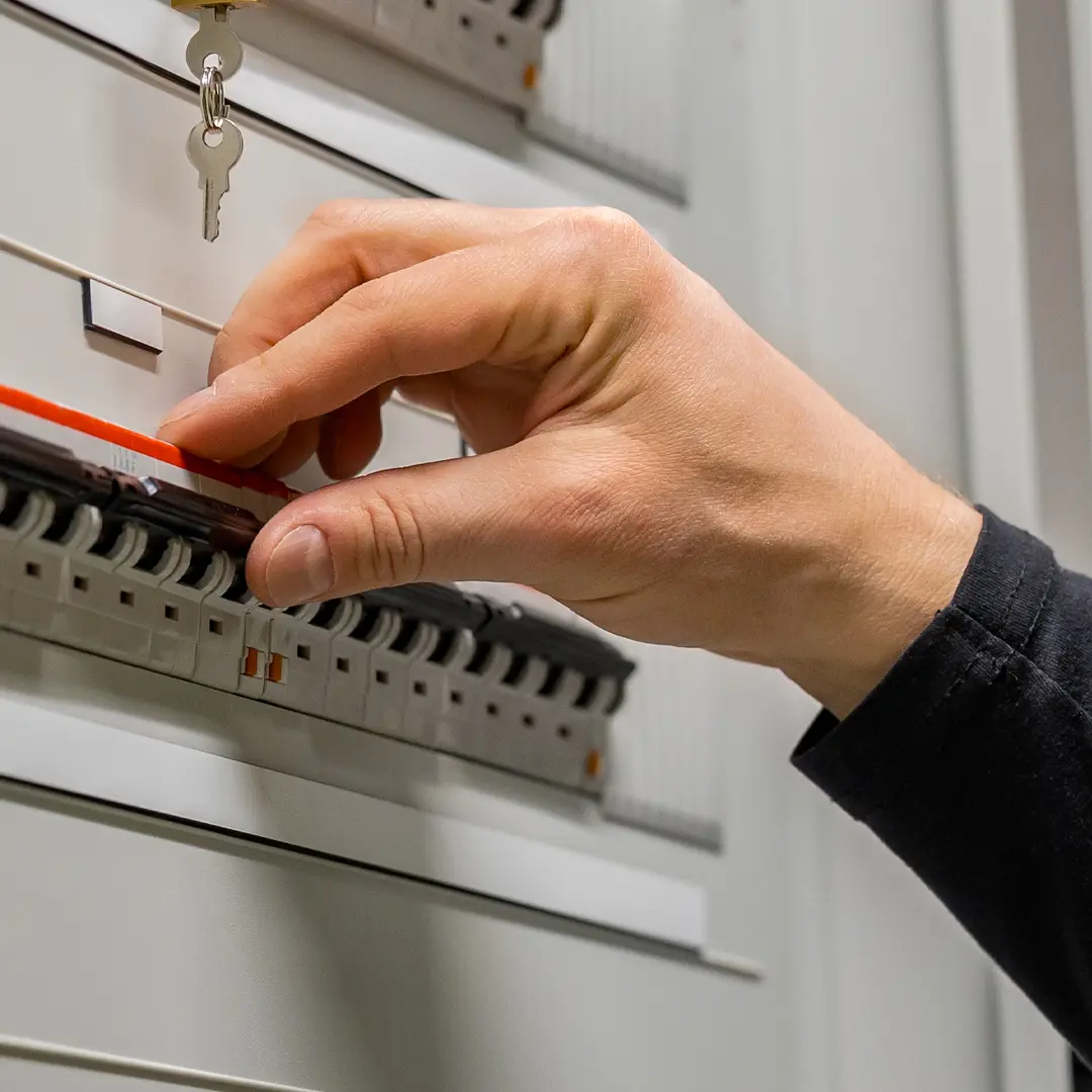 main sur un disjoncteur électrique
